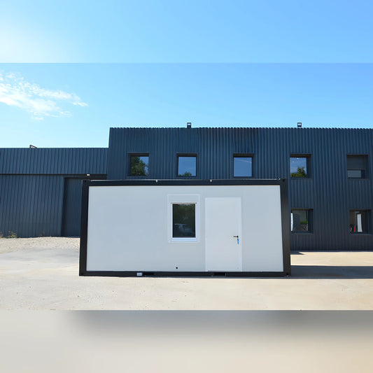 Bungalow bureau Eurocontex – façade avant avec fenêtre et porte, fond bâtiment industriel